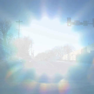 a double exposure of a suburban intersection and a close-up of the sun in the sky.